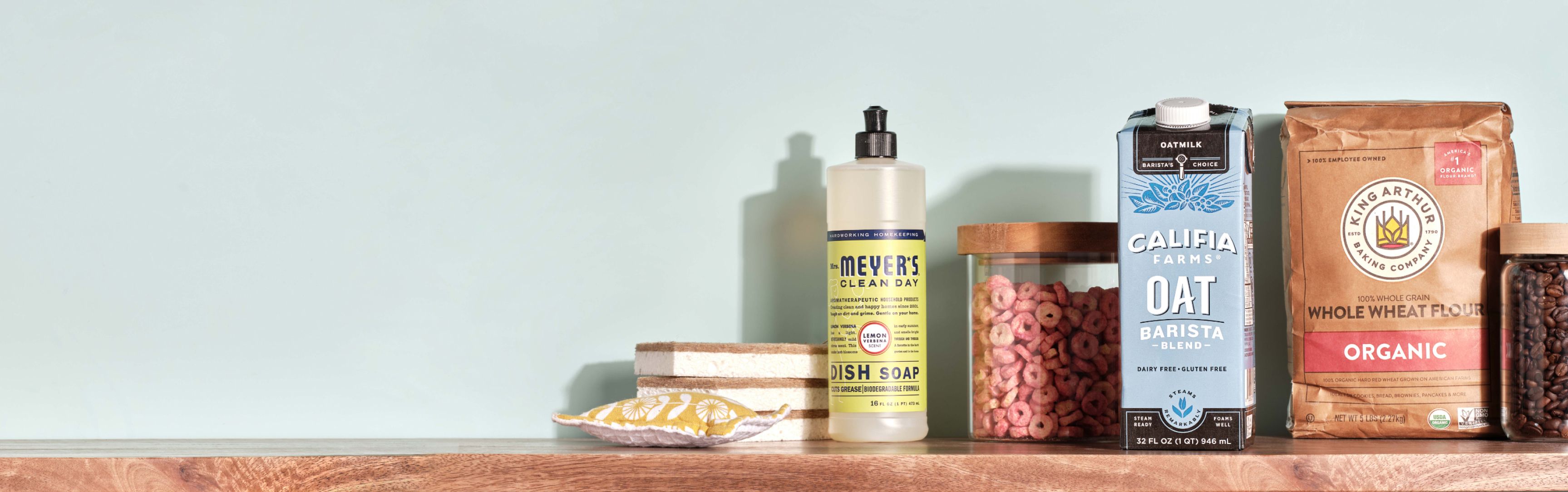 Products available at Thrive Market arranged on a shelf, including dish soap, oat milk, 